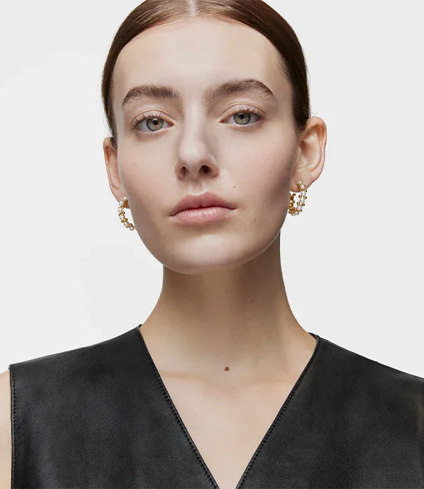 אישה עם עגילי חישוק זהב מהודרים ולבוש שחור, תכשיטים יוקרתיים CHOZEN