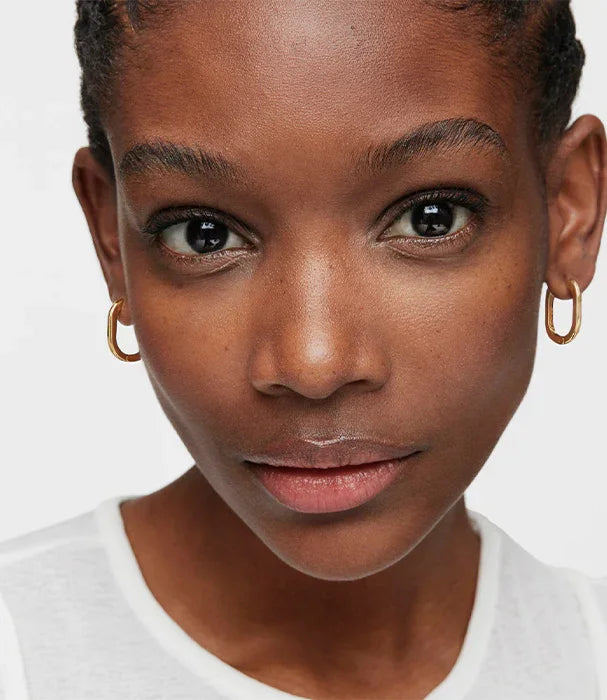 דיוקן אישה עם עגילי חישוק זהב, רקע לבן, קמפיין תכשיטים CHOZEN אלפא מותגים