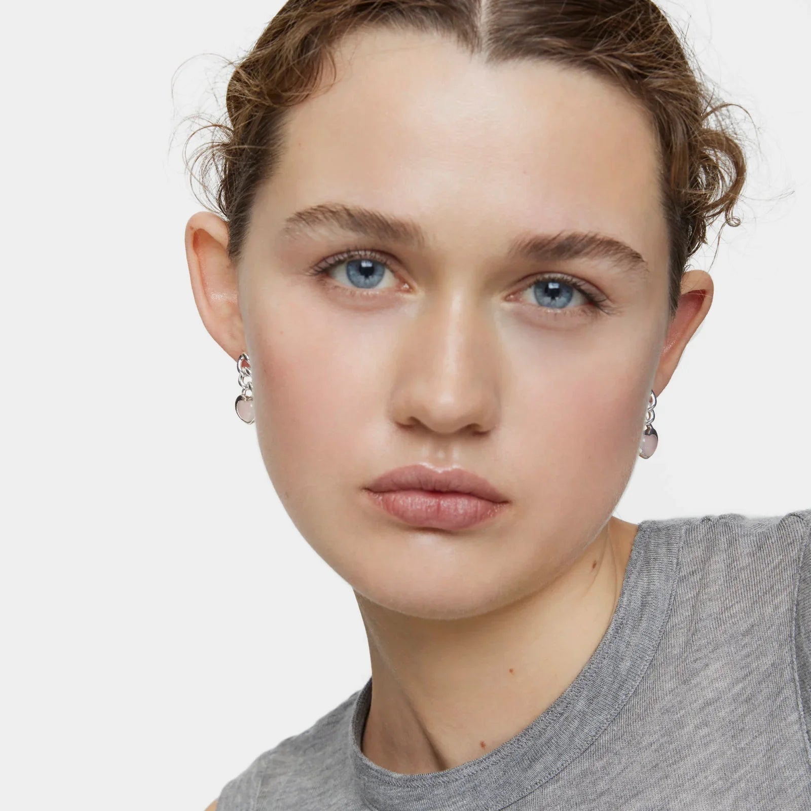 אישה עונדת עגילי כסף עם אבן, צילום תקריב, אופנה קיץ CHOZEN מבית קבוצת אלפא