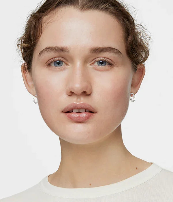 אישה עם עגילי חישוק כסף, רקע לבן, צילום תקריב, CHOZEN מותגים מובילים