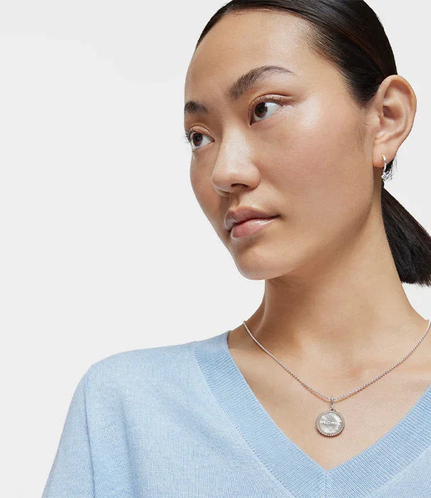 אישה עם שרשרת תליון כסף של CHOZEN, לבושה בסריג תכלת, צילום אופנה לקבוצת אלפא