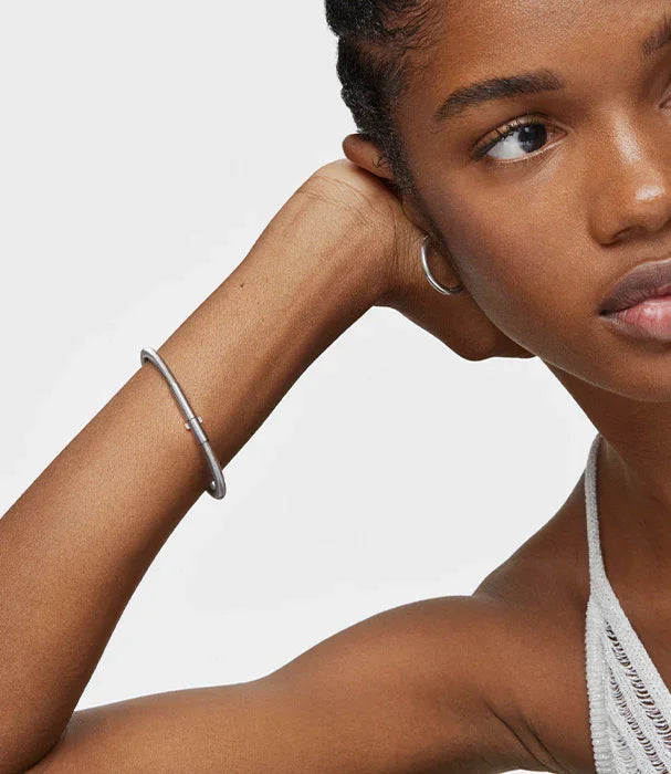 דוגמנית עונדת צמיד כסף מינימליסטי ועגיל חישוק, סטייל אופנתי מבית CHOZEN