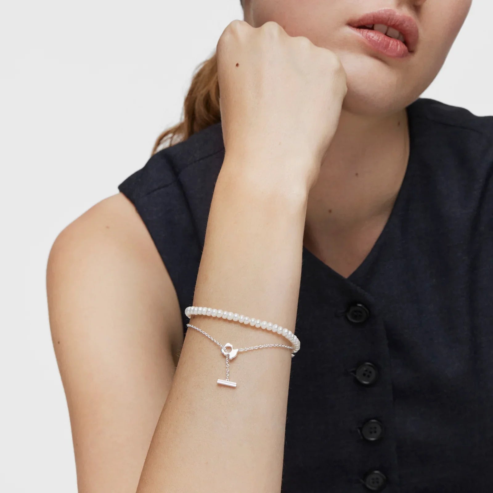 דוגמנית עונדת צמיד פנינים וצמיד כסף בעיצוב עדין, CHOZEN תכשיטים איכותיים לנשים