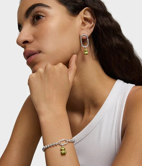 אישה עונדת עגיל וצמיד כסף עם תליון ירוק, תכשיטי מותגים מובילים CHOZEN