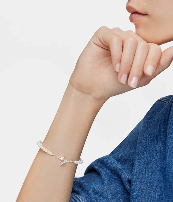 צמיד פנינים עדין לאישה מבית CHOZEN על יד בלבוש ג'ינס