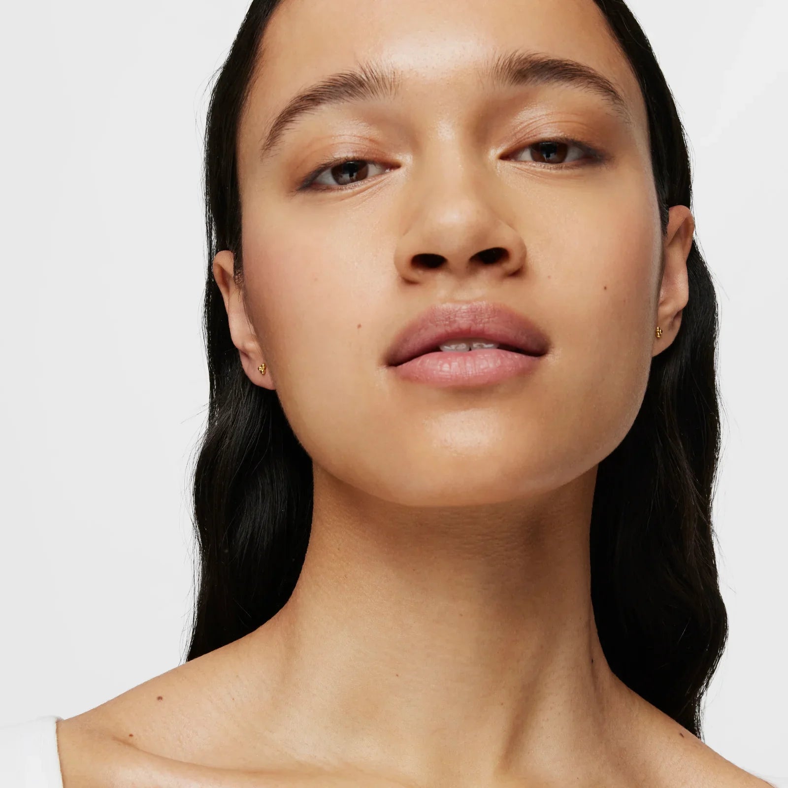 דיוקן אישה עם עגילי זהב קטנים, צילום קידום מכירות לאתר CHOZEN, רקע לבן