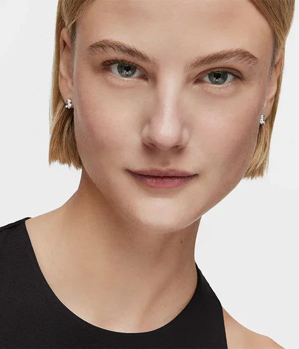 דוגמנית עם שיער בלונדיני קצר עונדת עגילי יהלום, צולם לחנות CHOZEN מותגים מובילים