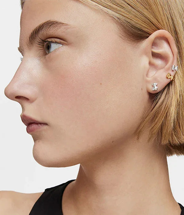 אישה עם שיער בלונדיני קצר עונדת עגילים עדינים מזהב וכסף, תכשיטי אופנה מבית CHOZEN