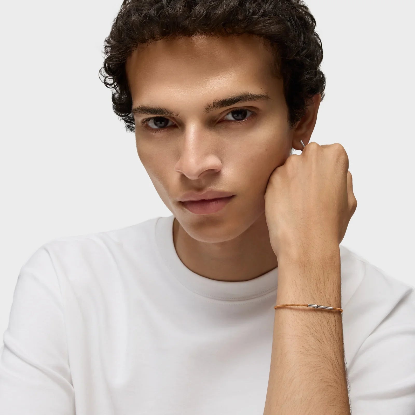 דוגמן לובש חולצת טי לבנה וצמיד דק, צילום תדמית למותג CHOZEN