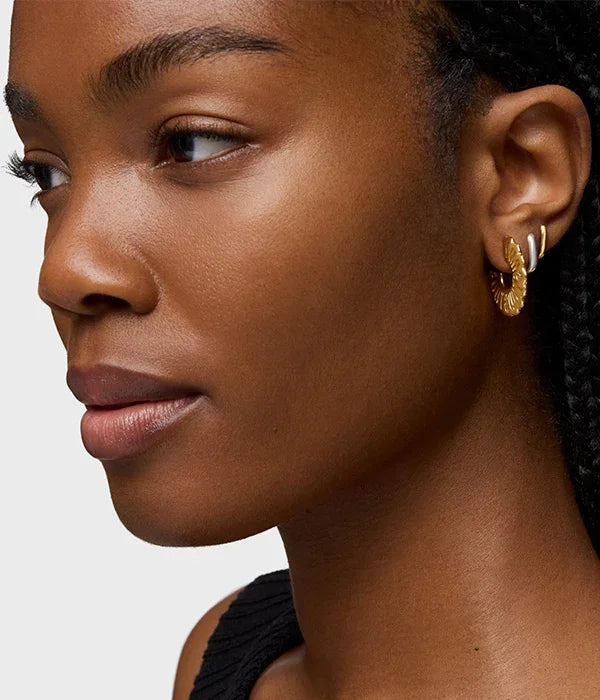 אישה עם עגילי זהב מודרניים, תקריב על הפנים, תכשיטים אופנתיים מקבוצת אלפא CHOZEN