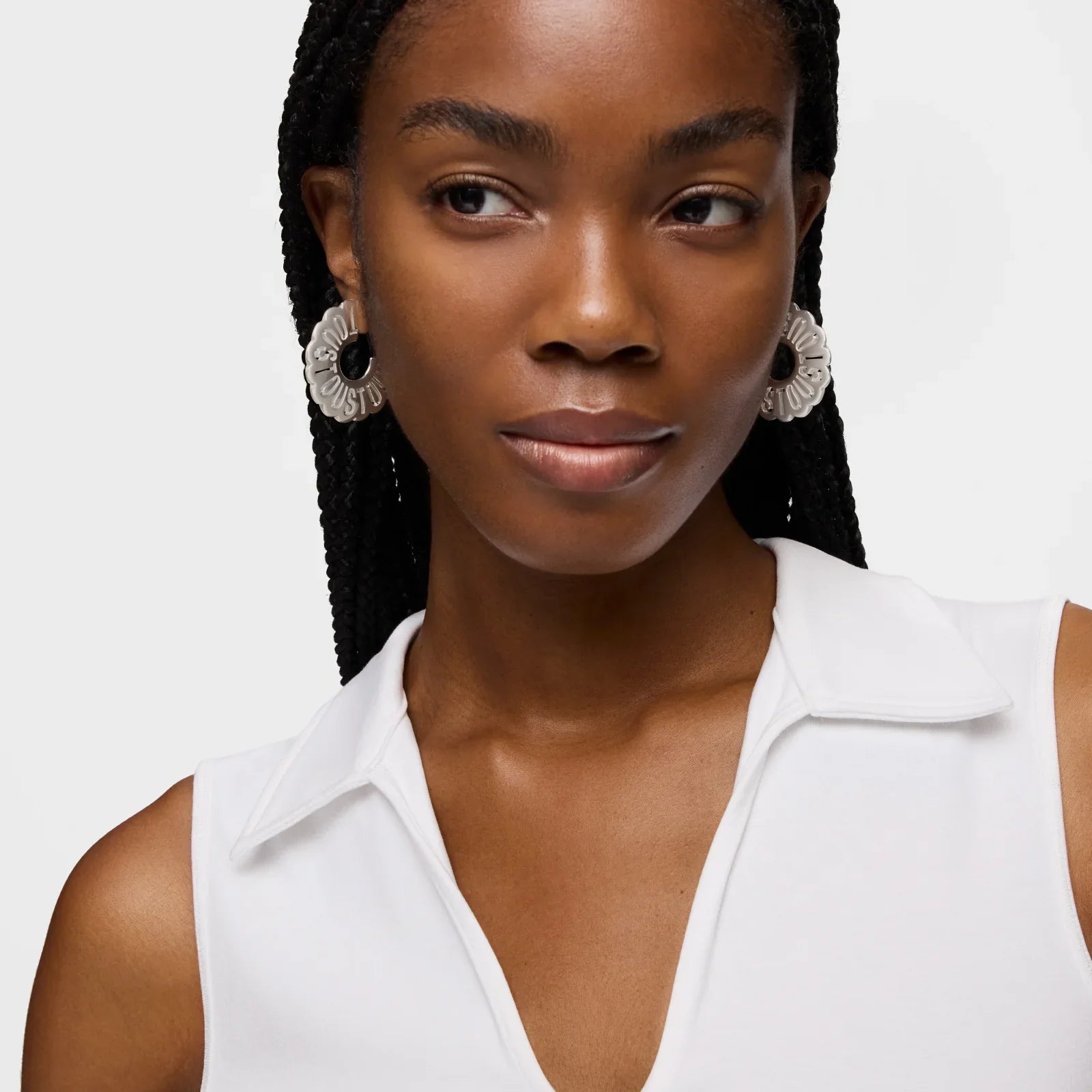 אישה עם עגילי חישוק גדולים, לובשת גופייה לבנה, אופנה מודרנית CHOZEN