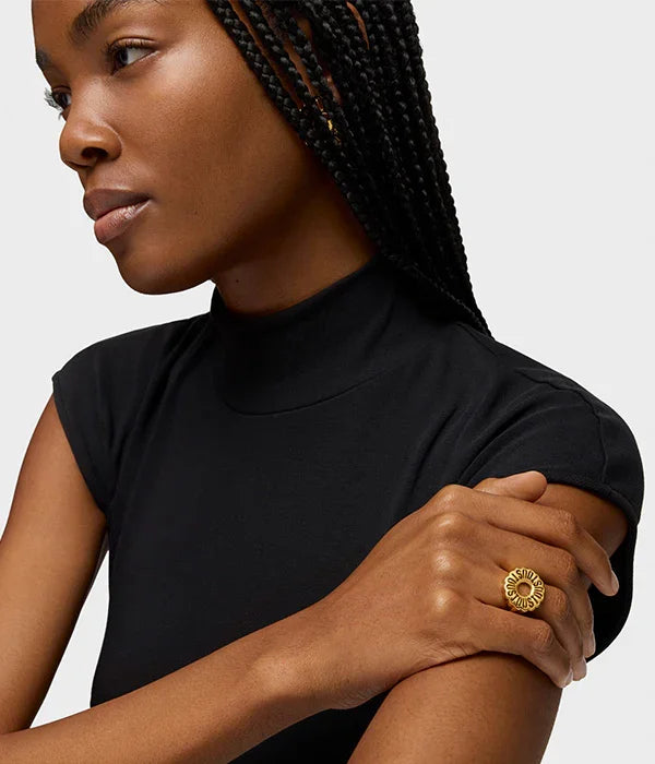 אישה לובשת חולצה שחורה עם טבעת זהב מעוצבת, תכשיטי אופנה מבית CHOZEN