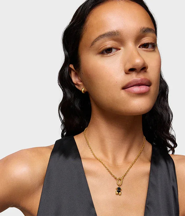 אישה לובשת שמלת ערב שחורה עם שרשרת זהב ותליון, עגיל זהב קטן, CHOZEN תכשיטים אופנתיים