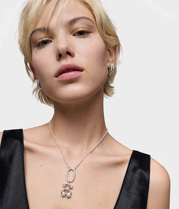 דוגמנית עם שמלת שחורה, שרשרת כסף תליון דוב ועגילי כסף, תכשיטים יוקרתיים CHOZEN