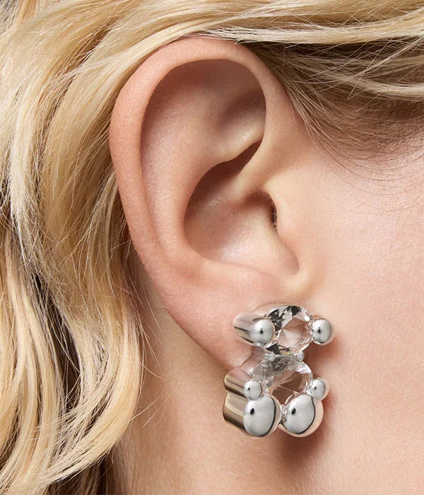 עגיל בעיצוב ייחודי עם אבנים שקופות וכדורי מתכת על אוזן אישה, CHOZEN תכשיטים יוקרתיים