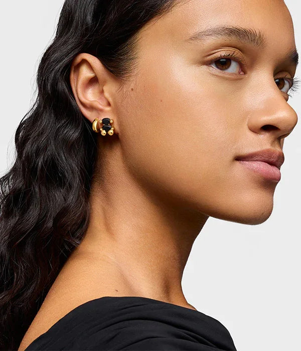 אישה עונדת עגיל זהב אופנתי עם אבן שחורה, צילום תקריב, CHOZEN מותגים מובילים