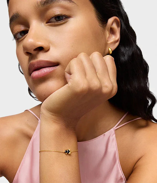 אישה לובשת עגיל זהב ושרשרת יד עדינה עם אבן שחורה, אופנה יוקרתית מ-CHOZEN