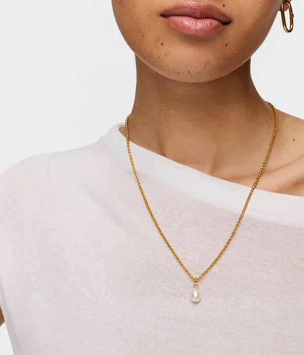 שרשרת זהב עם תליון פנינה על דוגמנית עם חולצה לבנה, תכשיטי CHOZEN