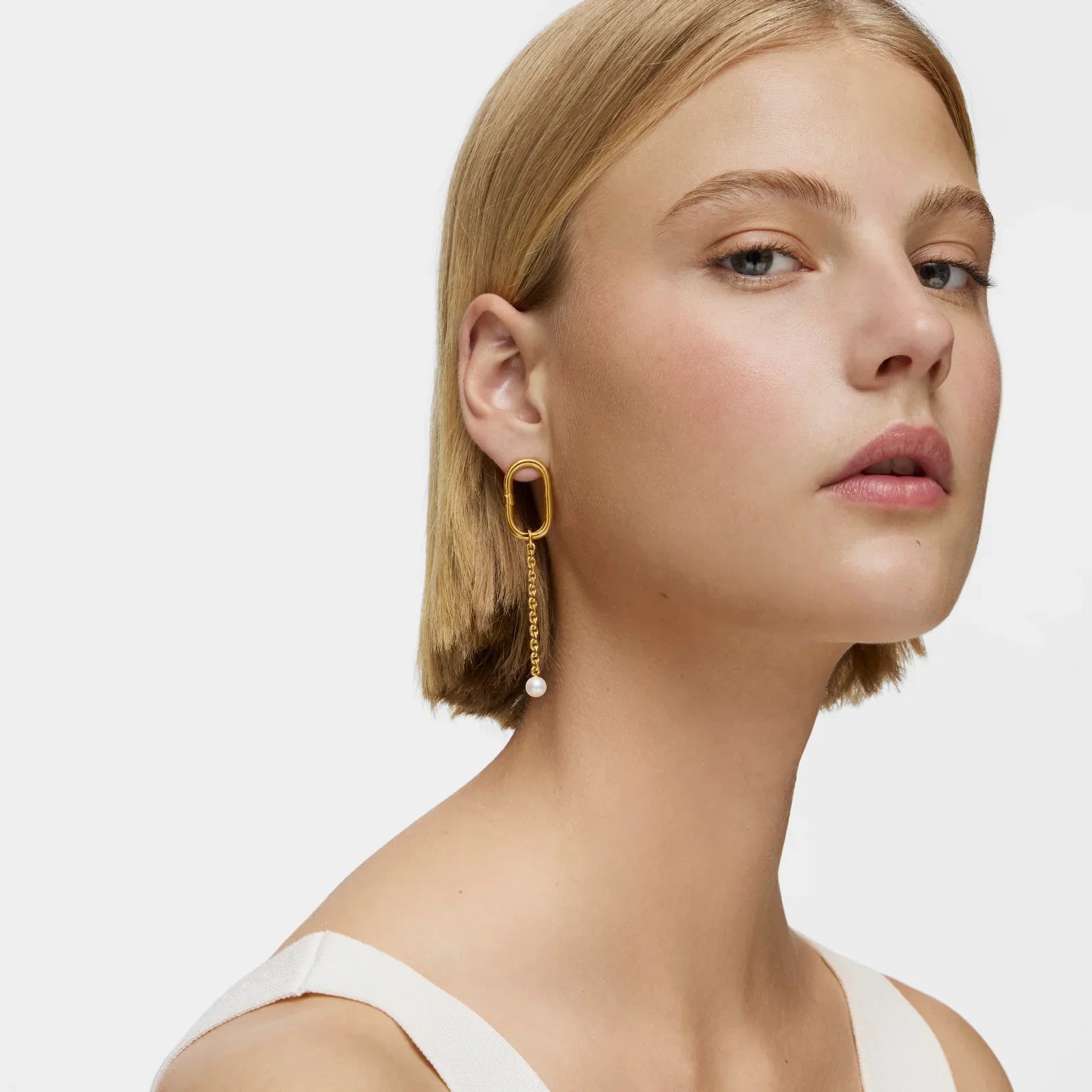 אישה עם עגיל זהב מודרני תלוי, רקע לבן, מבית CHOZEN קבוצת אלפא