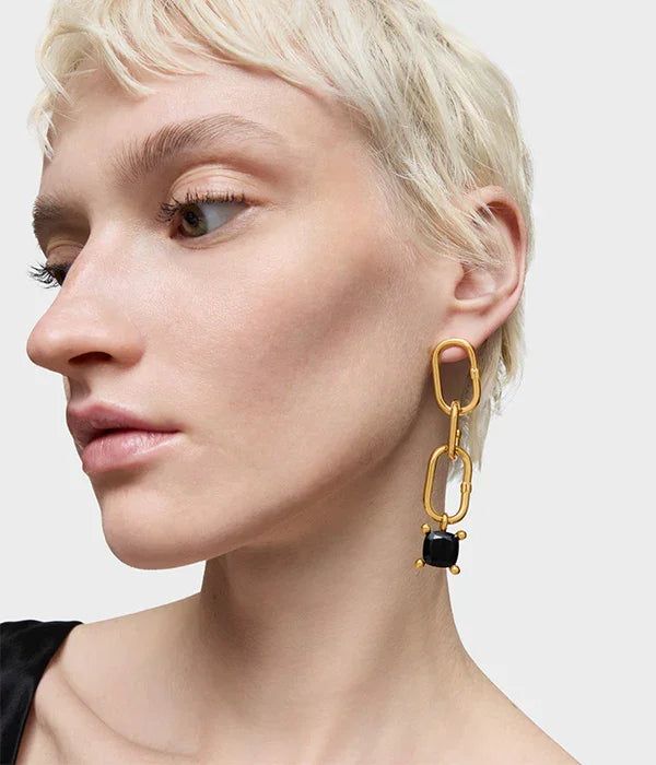 אישה עם עגיל זהב גדול בעיצוב מודרני משחור, צילום תדמית תכשיטים באתר CHOZEN