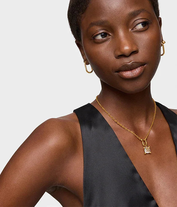 דוגמנית עונדת שרשרת זהב ועגילי זהב, לבושה בשמלה שחורה אלגנטית, CHOZEN תכשיטים