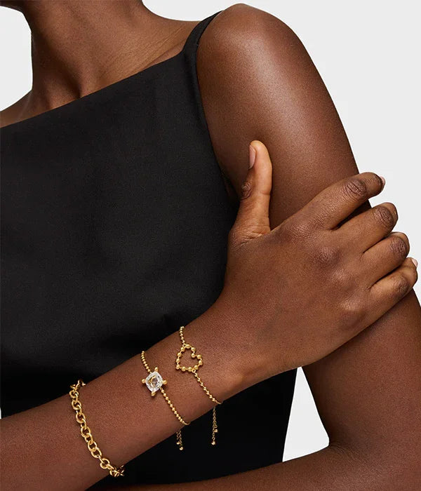 אישה עם שמלה שחורה עונדת צמידי זהב יוקרתיים CHOZEN תכשיטים אופנתיים