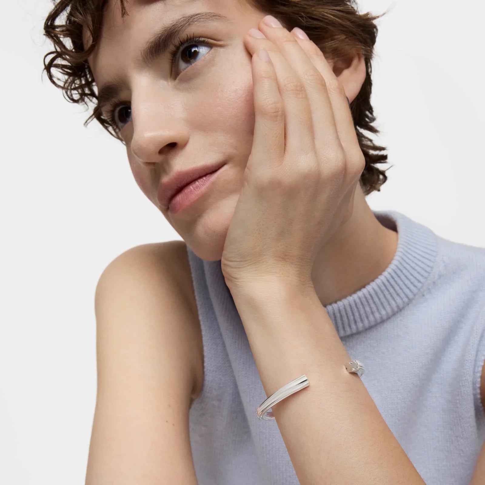 אישה עם שיער קצר לובשת צמיד כסף אלגנטי, צולם בסטודיו, CHOZEN מותגים מובילים