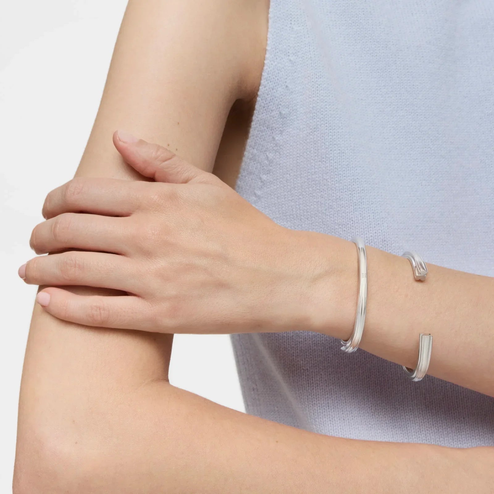 צמידי כסף אלגנטיים על יד של אישה בלבוש סריג, תכשיטים מבית CHOZEN