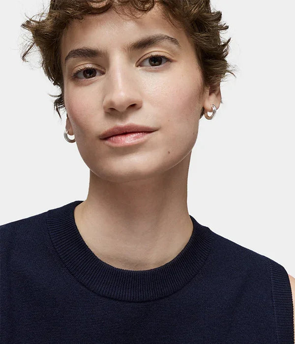 דוגמנית עם שיער קצר ועגילי חישוק לובשת סריג כחול כהה, צילום לאתר CHOZEN מותגים מובילים