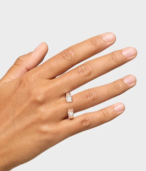 יד עם טבעת כסף פתוחה, תכשיט יוקרתי של CHOZEN, צילום על רקע חלק