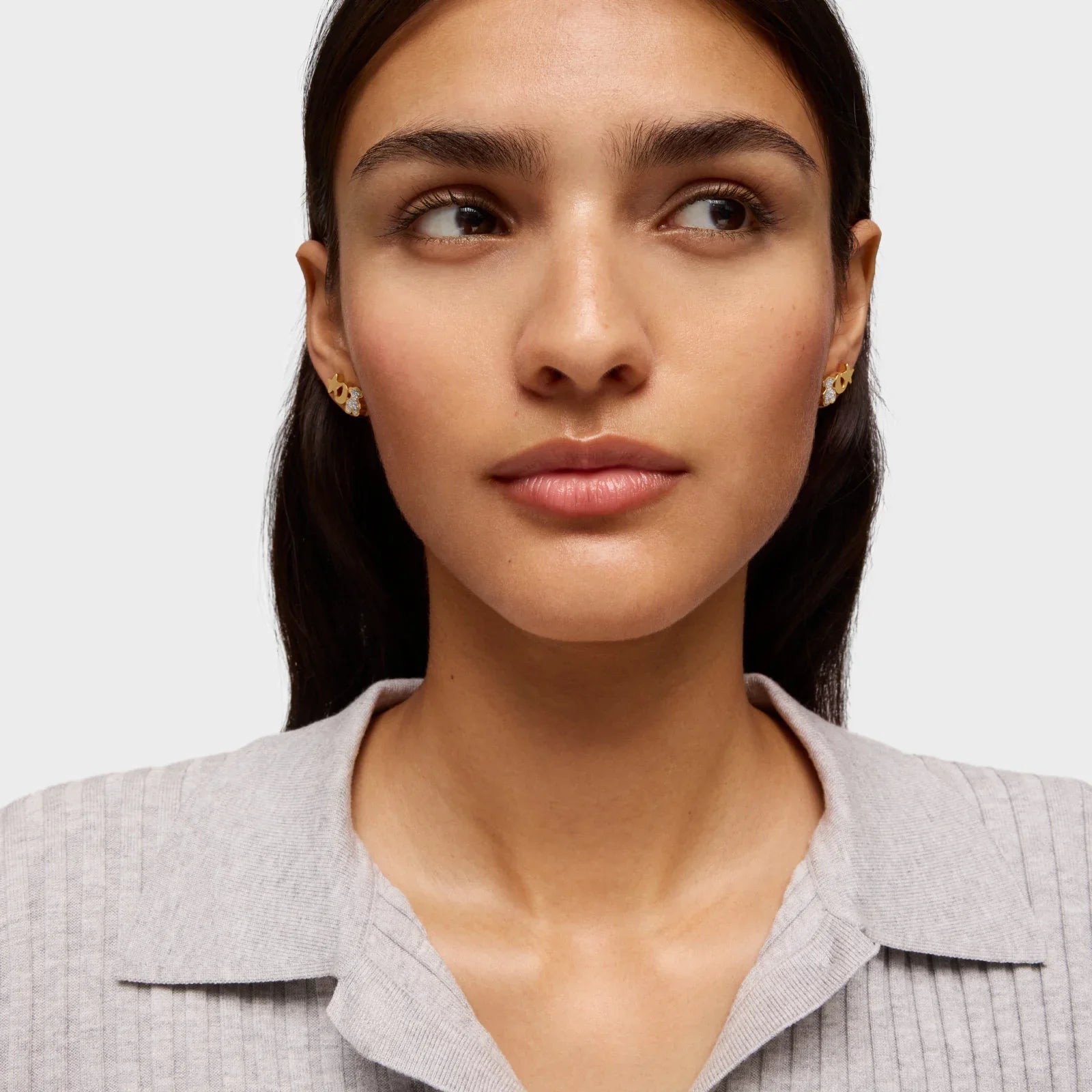 אישה עונדת עגילי זהב מעוצבים, צילום תקריב לאתר CHOZEN מותגים מובילים