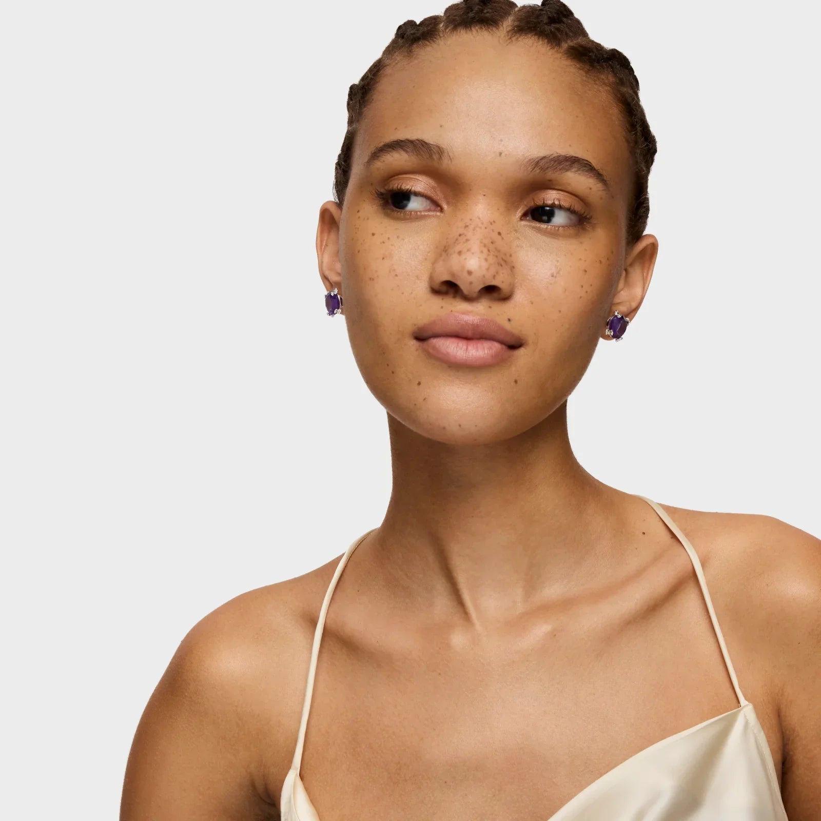 דוגמנית עם עגילי אבן סגולה, שמלת סatin לבנה, צילום אופנה ל-CHOZEN