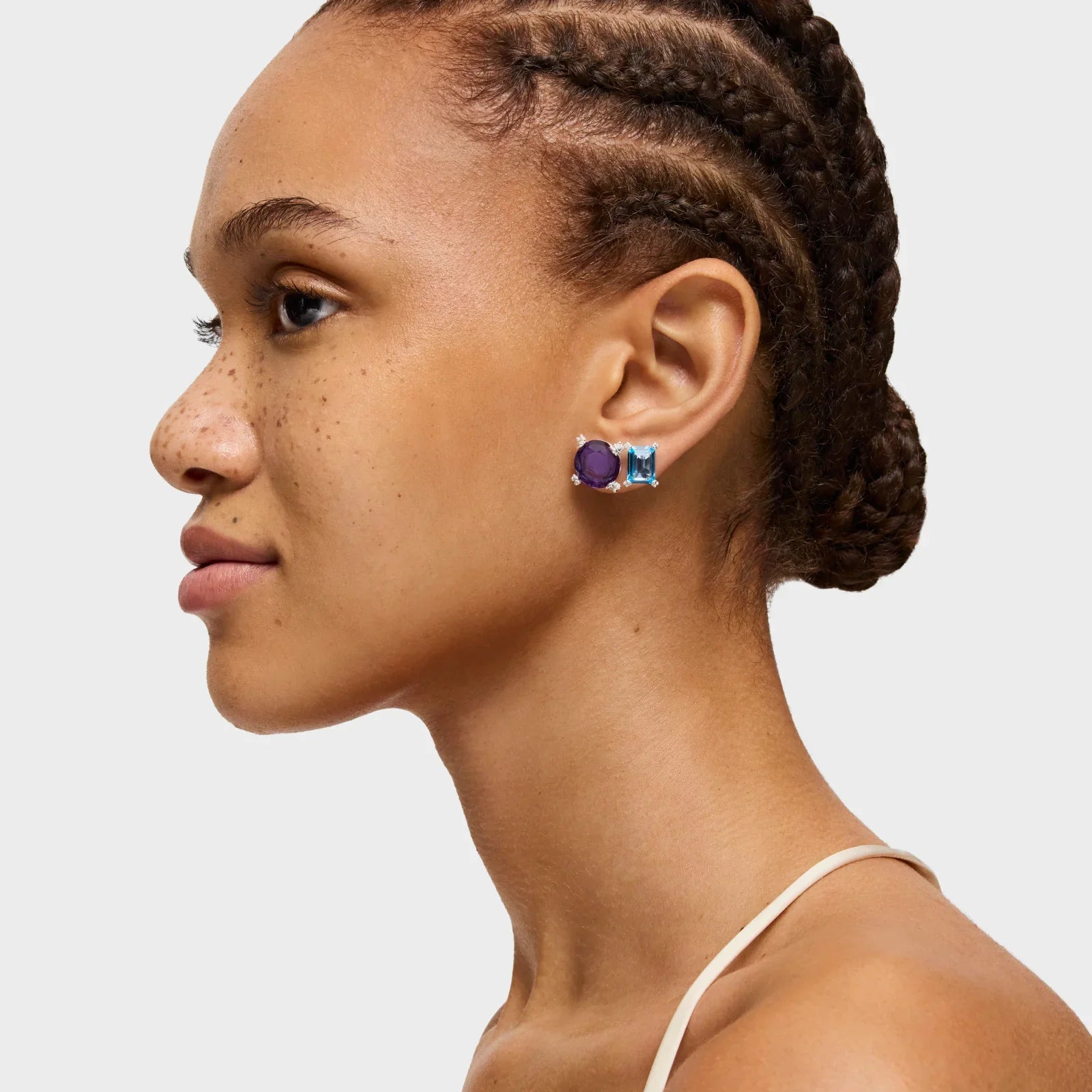 דוגמנית עונדת עגילי אבן סגולה ותכלת, צילום תכשיטים יוקרתי ממותג CHOZEN