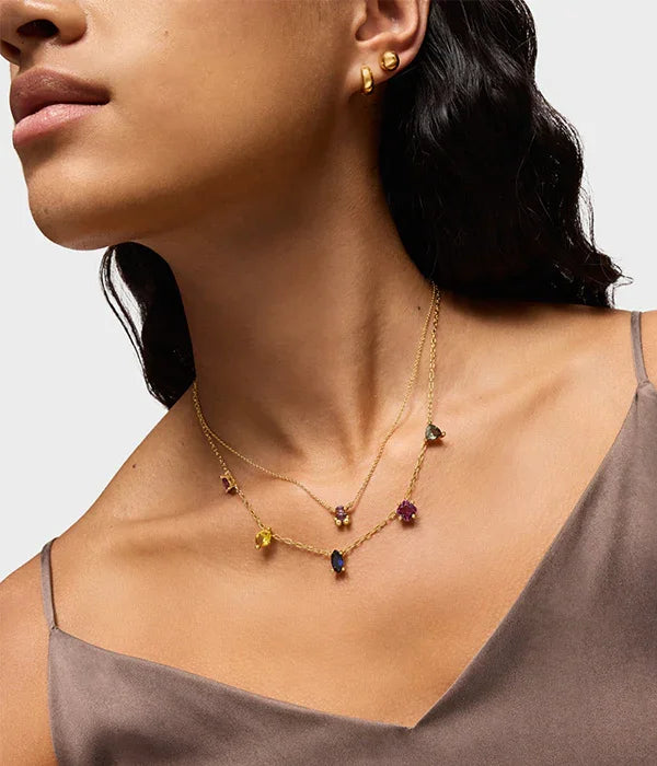 דוגמנית עונדת שרשרת זהב עם אבני חן צבעוניות ועגילי זהב, CHOZEN מותגים מובילים