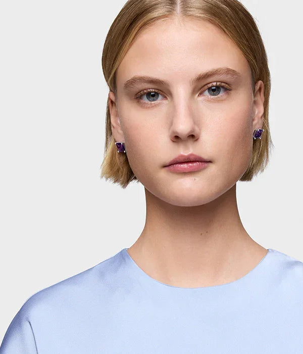 אישה עם שיער בלונד קצר עונדת עגילי אבן סגולה, רקע בהיר, אופנה יוקרתית מ-CHOZEN