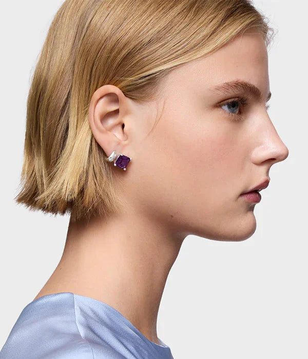 אישה עם עגיל כסף ואבן סגולה, רקע אפור, אופנה יוקרתית CHOZEN