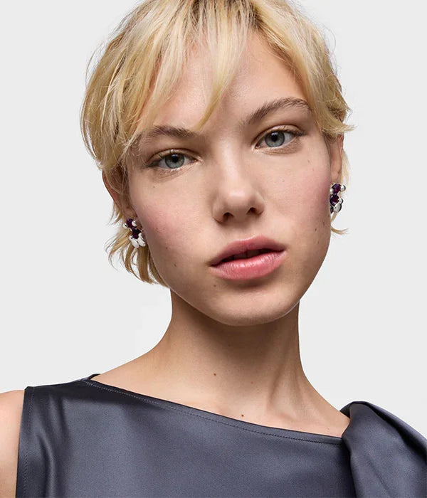 דוגמנית עם עגילי פרחים סגולים ולבנים, חולצת סאטן כהה, צילום אופנה ל-CHOZEN