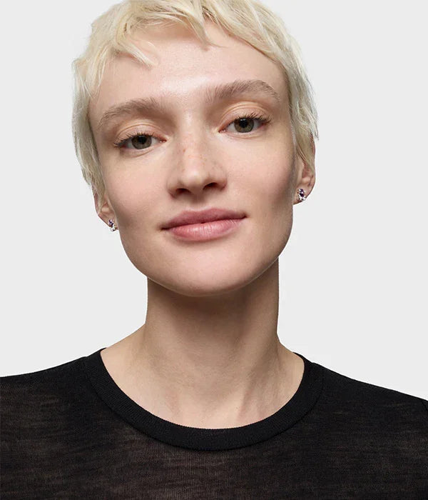 דוגמנית עם שיער בלונד קצר, חולצה שחורה ועגילים קטנים, אופנה יוקרתית CHOZEN