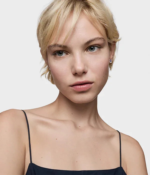 דוגמנית עם שיער בלונדיני קצר עונדת עגילי CHOZEN, רקע בהיר, אופנה אלפא קבוצה