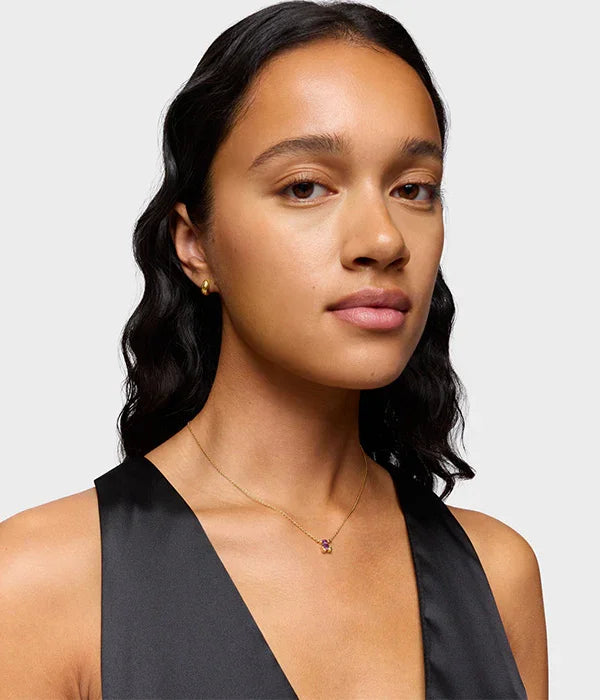 דוגמנית עונדת שרשרת זהב עדינה עם תליון צבעוני, צולם לאתר CHOZEN מותגים מובילים