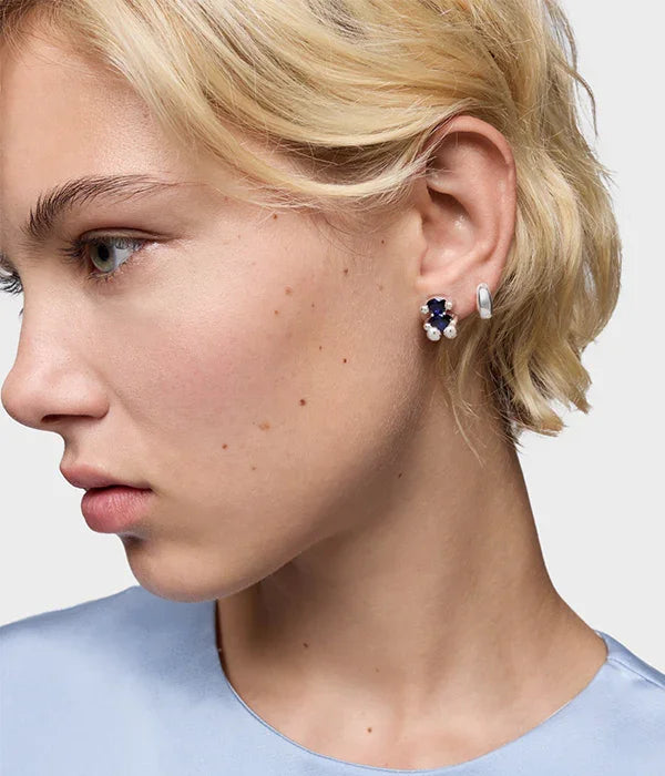 דוגמנית עונדת עגילי כסף מעוצבים עם אבן כחולה ופרל, צילום תקריב לקטלוג CHOZEN