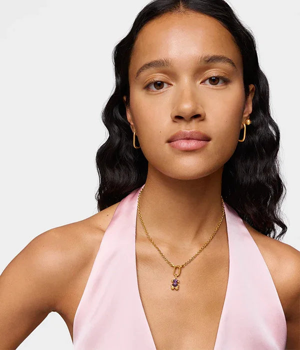 אישה עונדת שרשרת תליון עם אבני חן ועגילי זהב, בלבוש ורוד אופנתי, CHOZEN מותגים מובילים