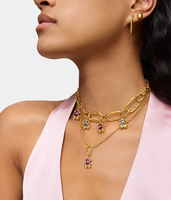 דוגמנית עונדת שרשרת זהב עם תליוני אבני חן צבעוניים ועגילים זהב, אופנת תכשיטים יוקרתיים מבית CHOZEN