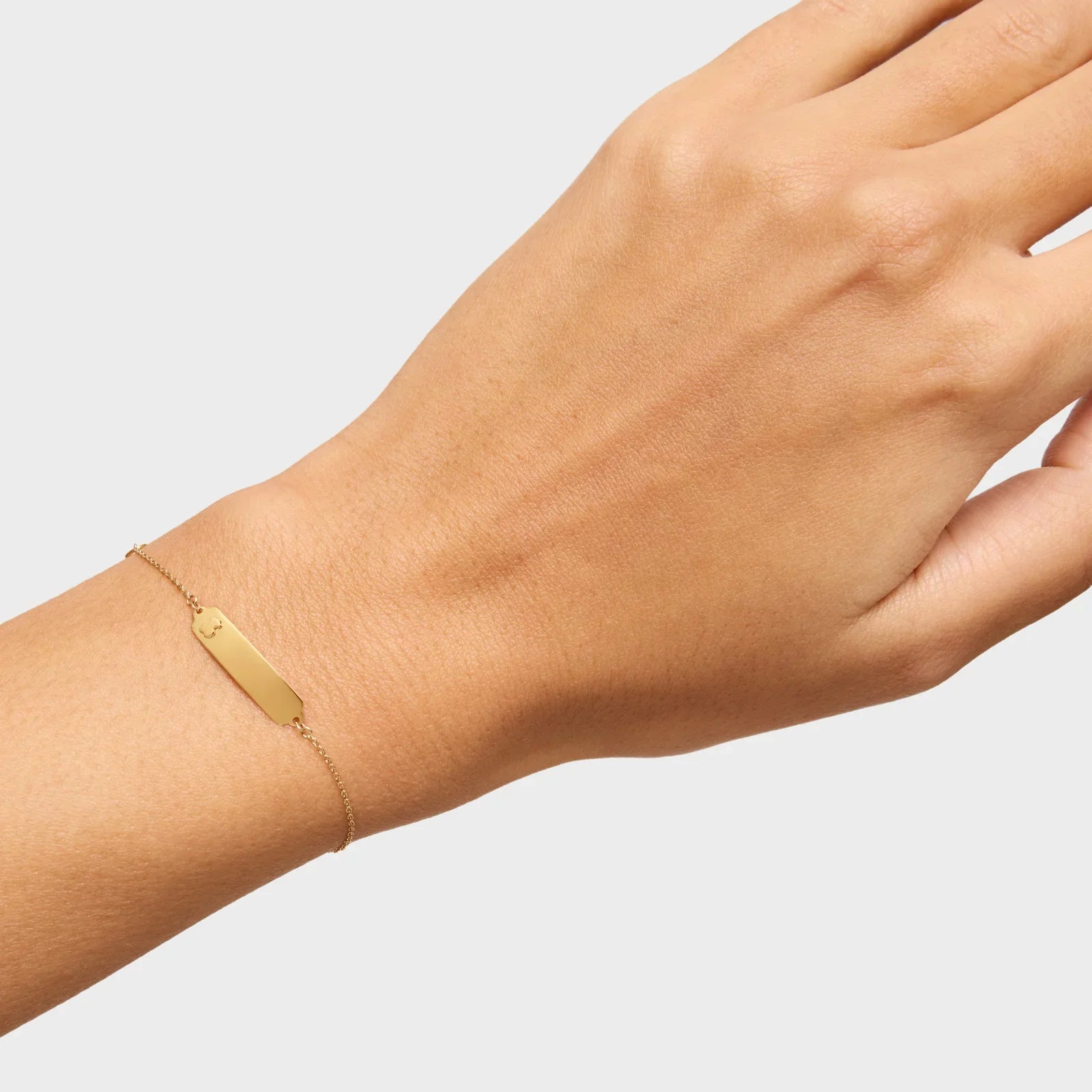 צמיד זהב עדין עם לוחית שטוחה על פרק כף היד, צילום לאתר CHOZEN