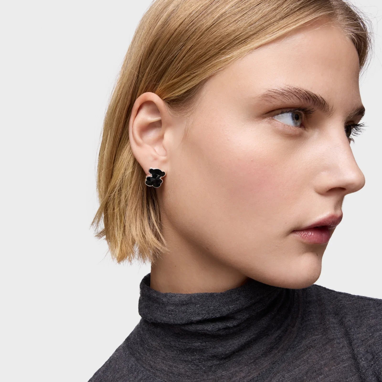 עגיל פרח שחור אופנתי על אוזן אישה, תכשיט יוקרתי מבית CHOZEN, צילום תקריב מקצועי