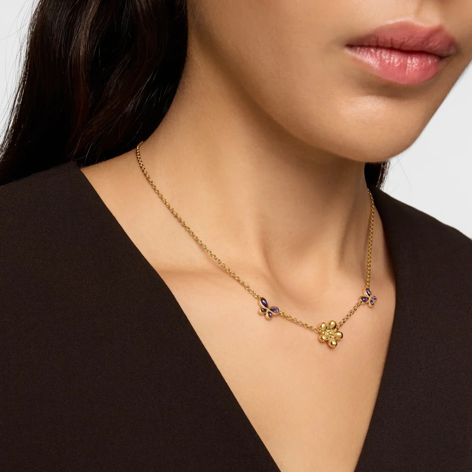 שרשרת זהב עדינה עם תליוני פרחים סגולים וזהובים על צוואר של אישה, CHOZEN מותגים מובילים