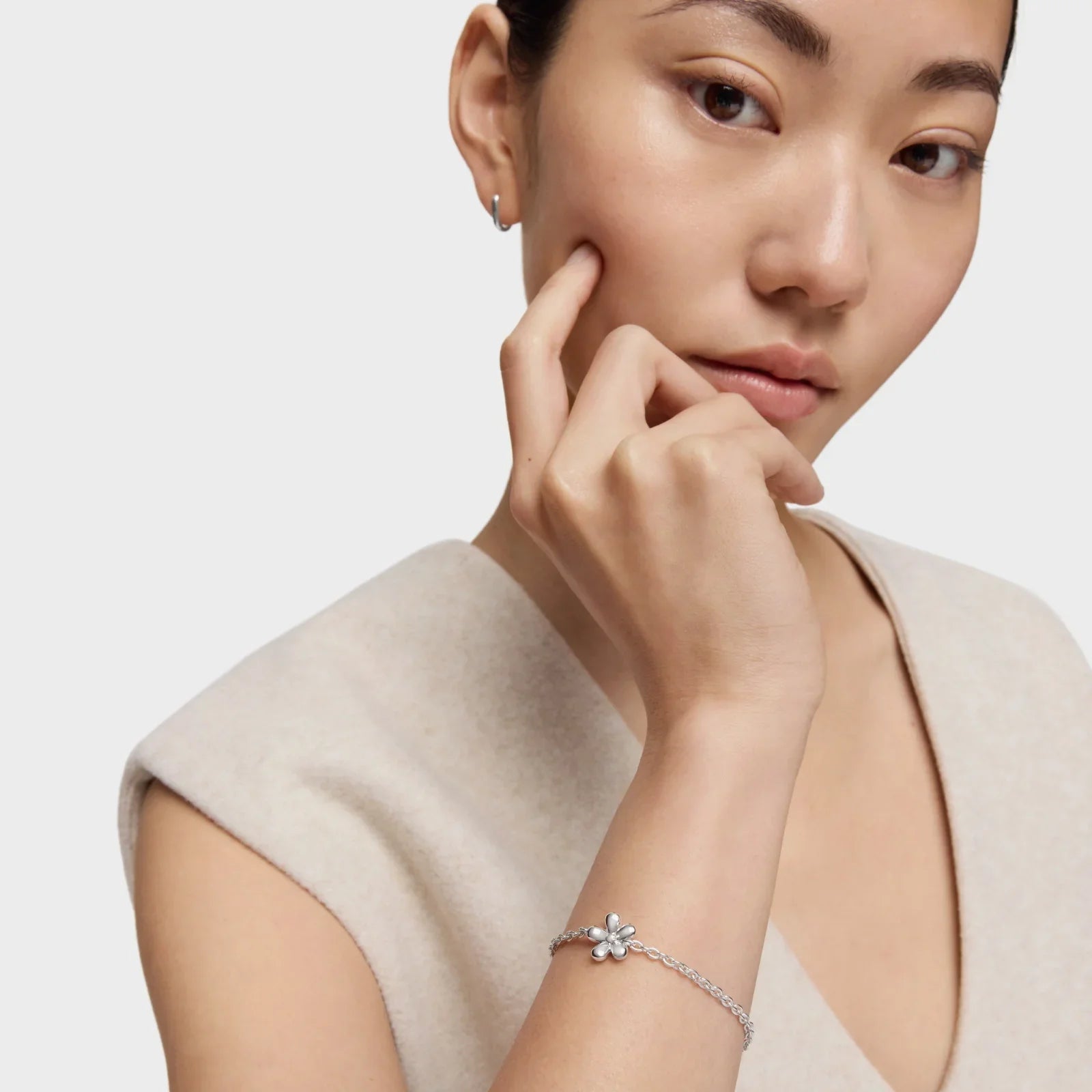 דוגמנית עונדת צמיד כסף עדין עם תליון פרח, צולם לקמפיין CHOZEN, תכשיטי אופנה יוקרתיים