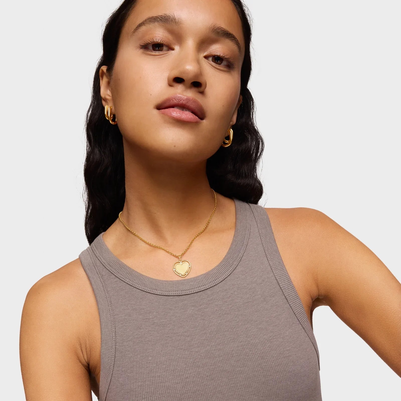 אישה עונדת שרשרת תליון זהב בצורת לב ועגילים, צילום תדמית לאופנה ב-CHOZEN