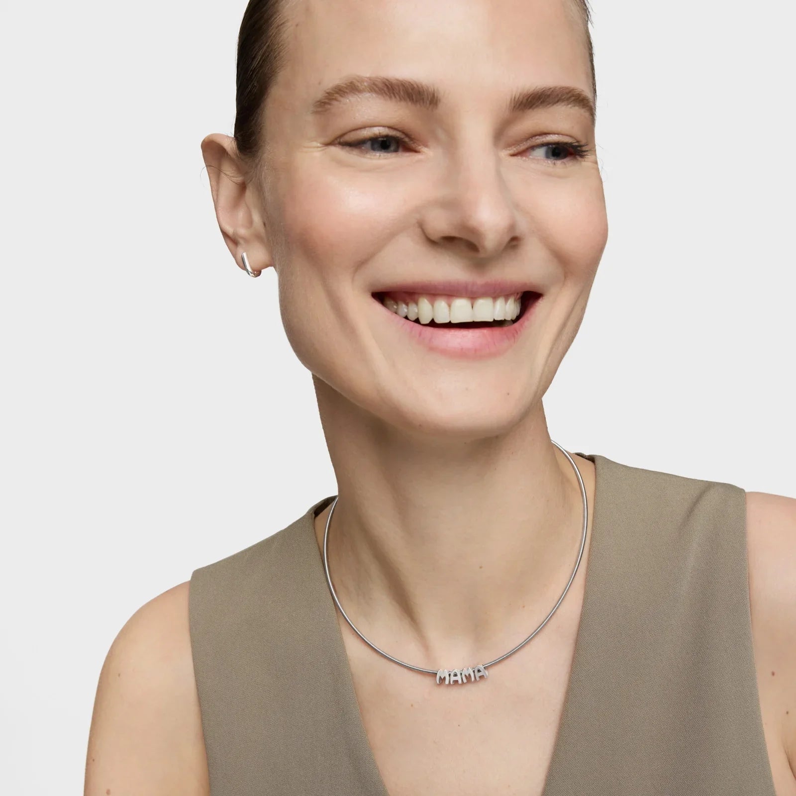 אישה מחייכת עונדת שרשרת כסף עם תליון 'MAMA', אופנה אלגנטית, CHOZEN מותגים מובילים