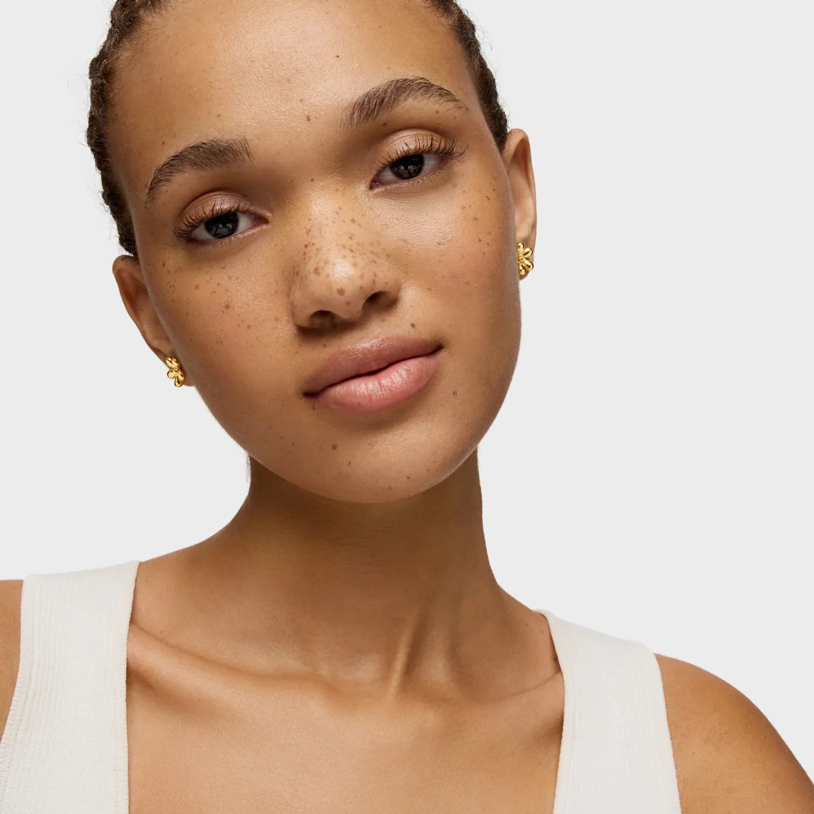 דוגמנית עונדת עגילי זהב פרח בחנות CHOZEN, צילום אופנה רקע לבן